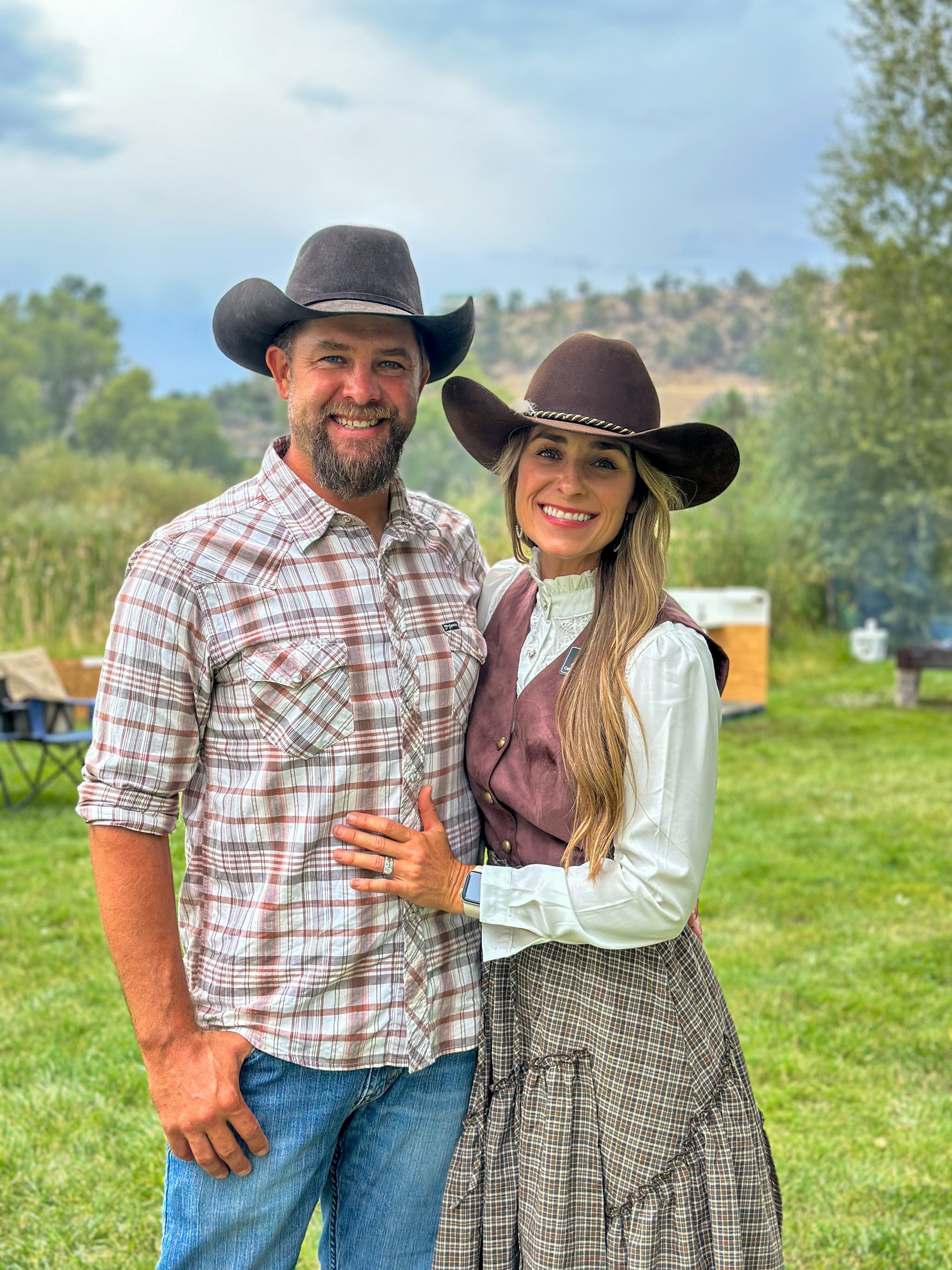 Couple in western attire with cowboy hats at the chuckwagon dinner