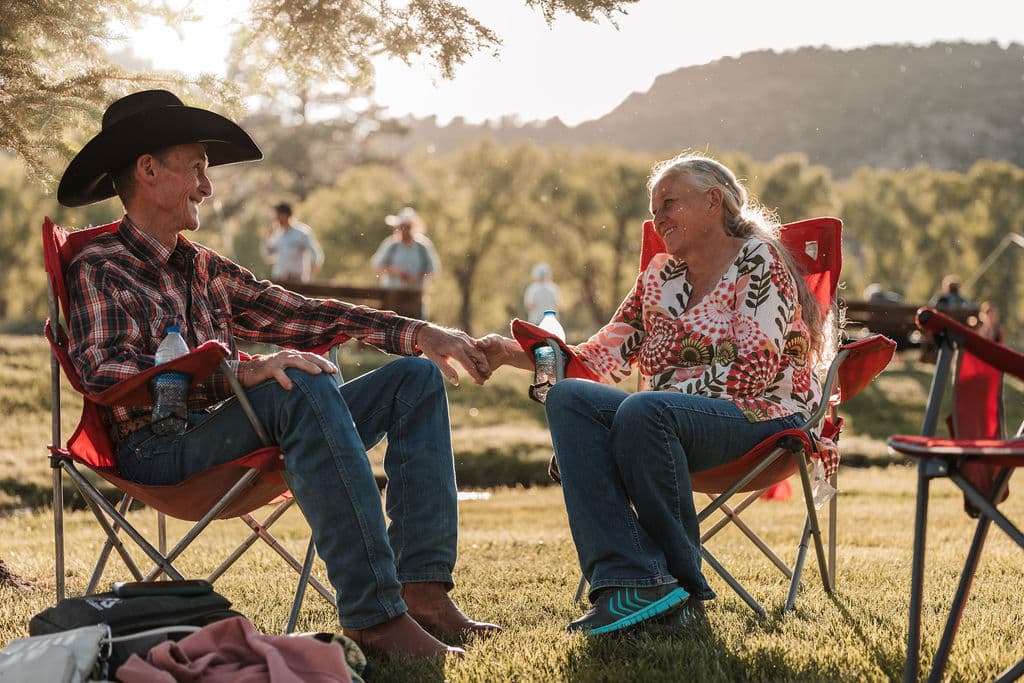 An older couple sharing a warm moment in their lawn chairs in the golden evening sun