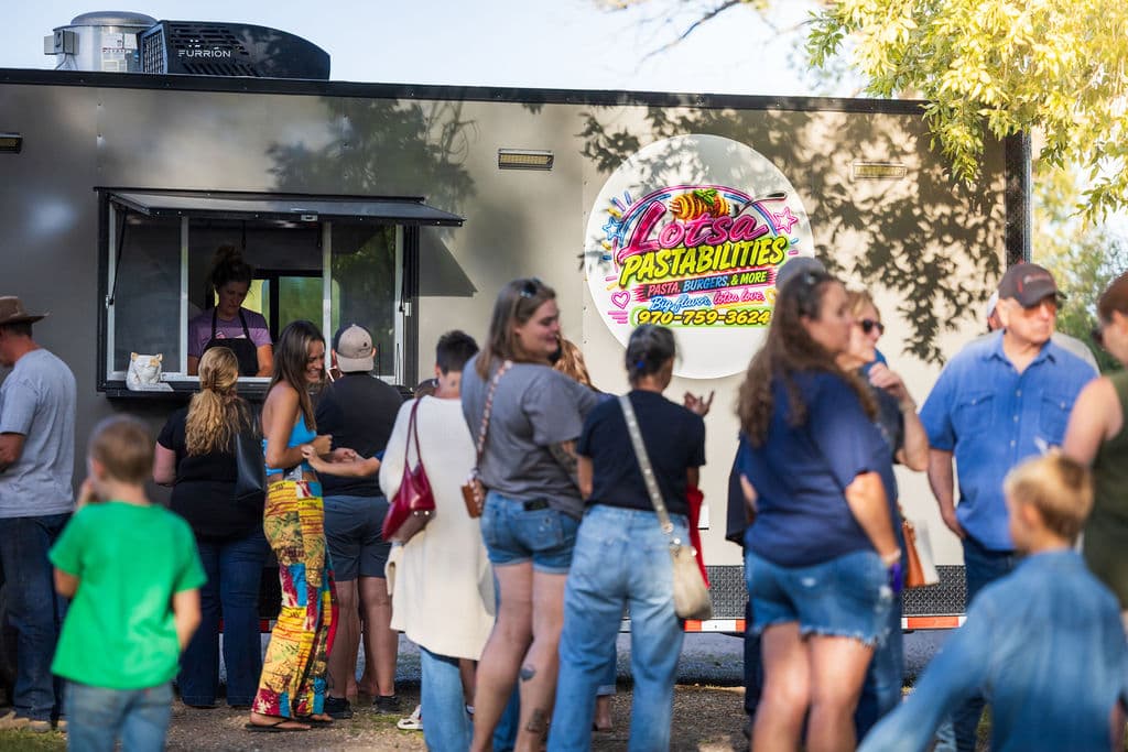A line of hungry guests waiting at the Lotsa Pastabilities food truck on the ranch grounds