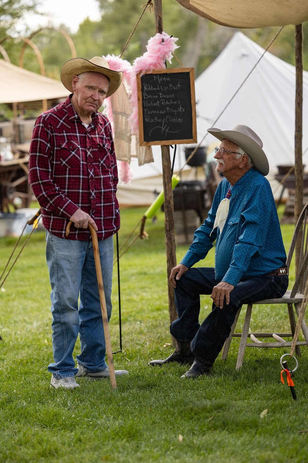 Two chuckwagon participants visiting beside the camp