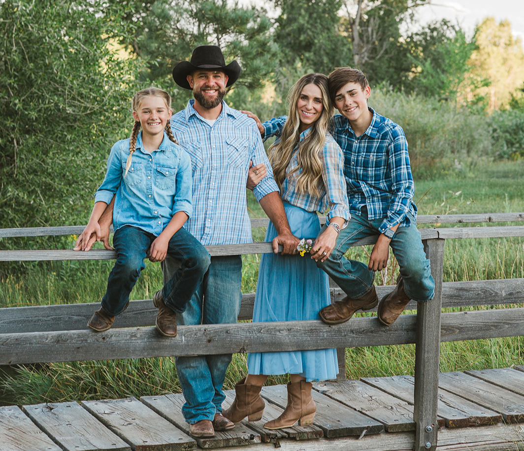 The Black family on a rustic wooden fence at L-J Ranch