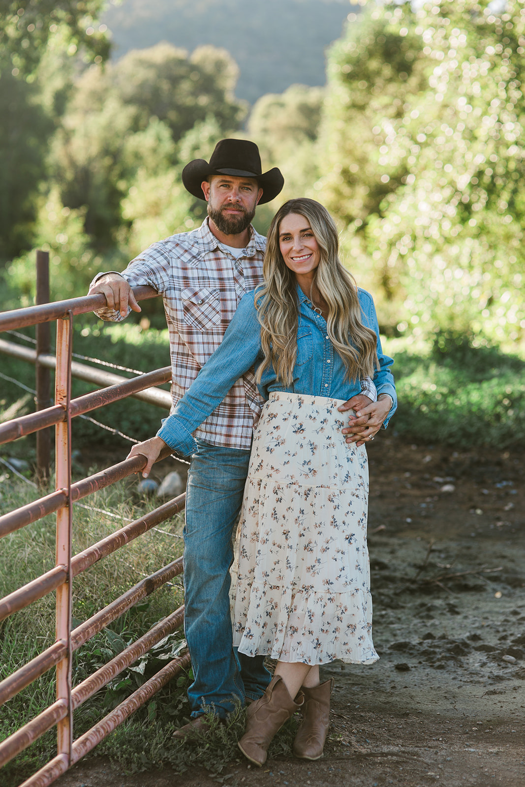 Paul and Krii Black standing together by a rustic gate at L-J Ranch