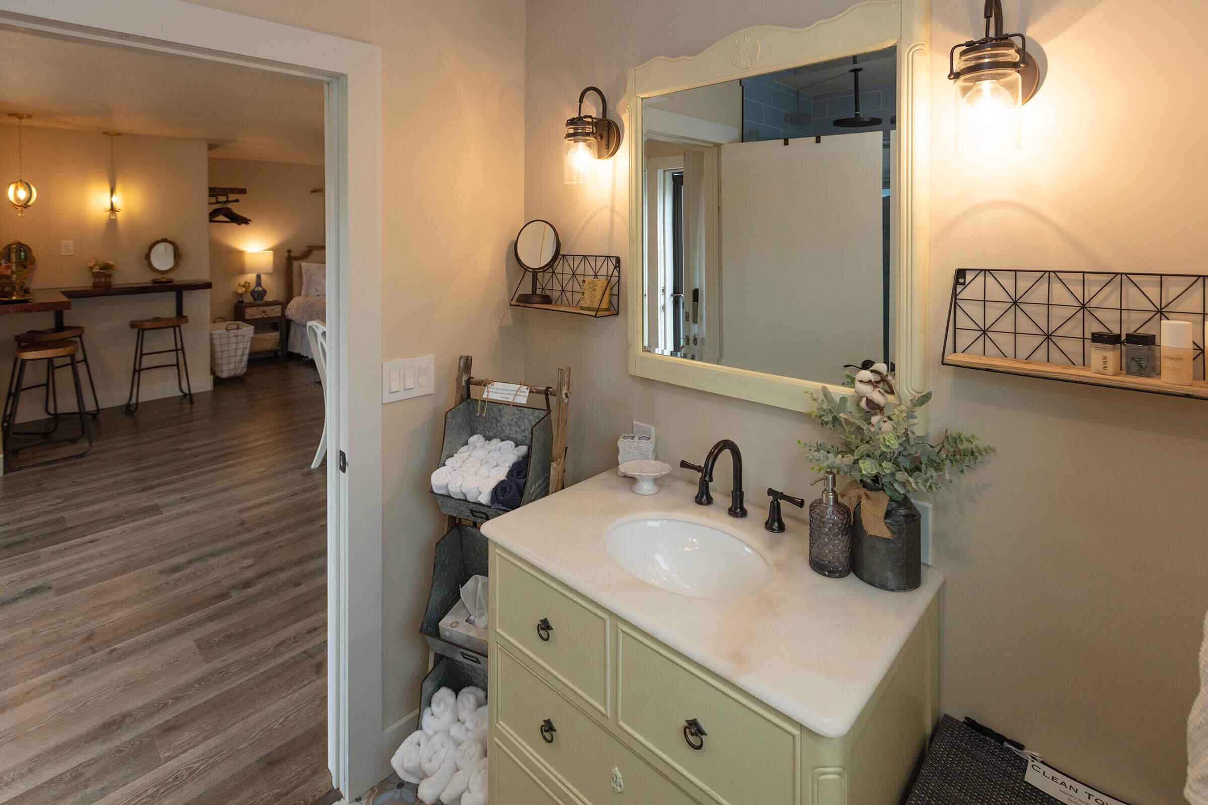 The Loft bathroom with sage green vintage vanity and farmhouse fixtures