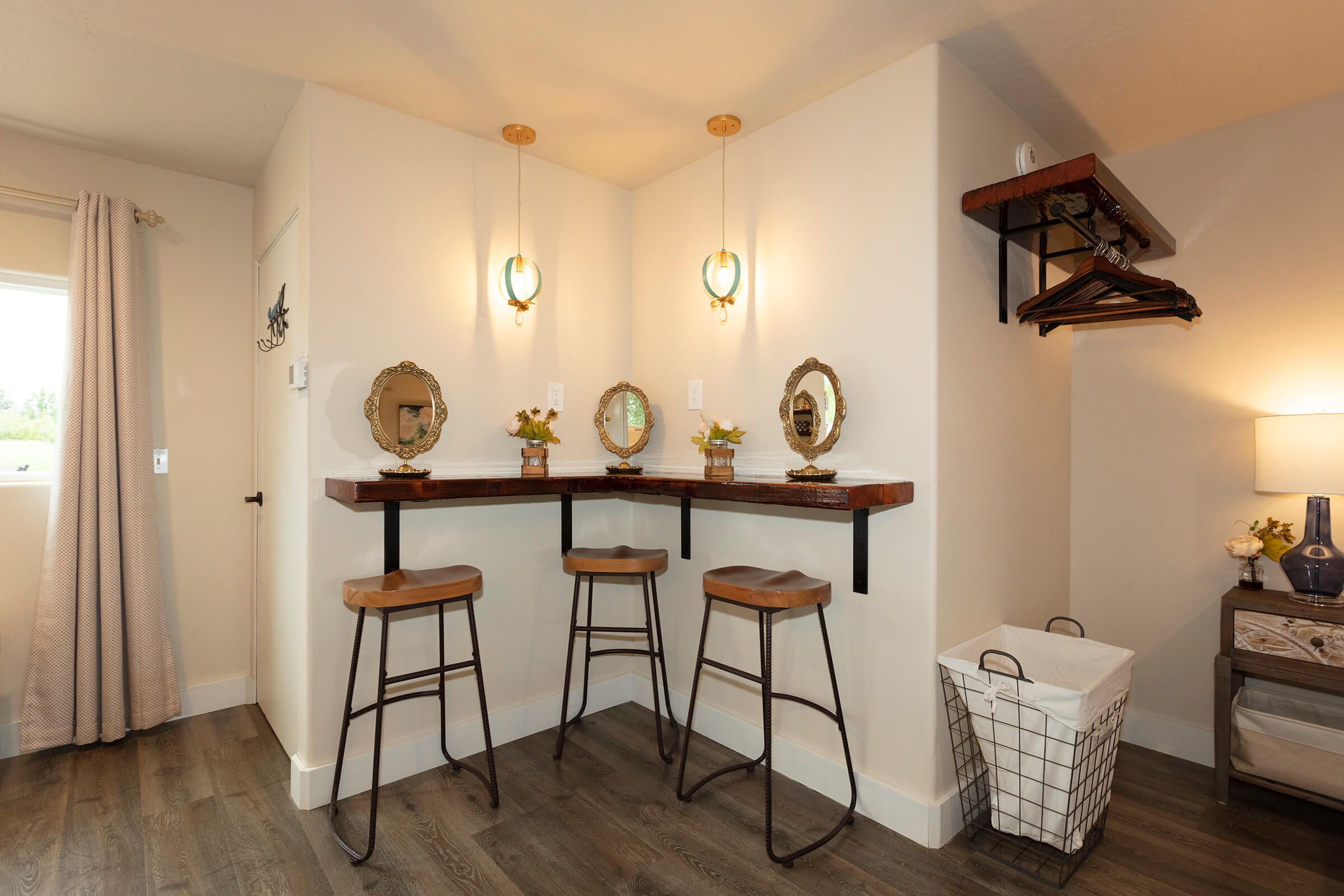 The Loft bridal bar with three wooden stools, ornate gold-framed mirrors, and pendant lights