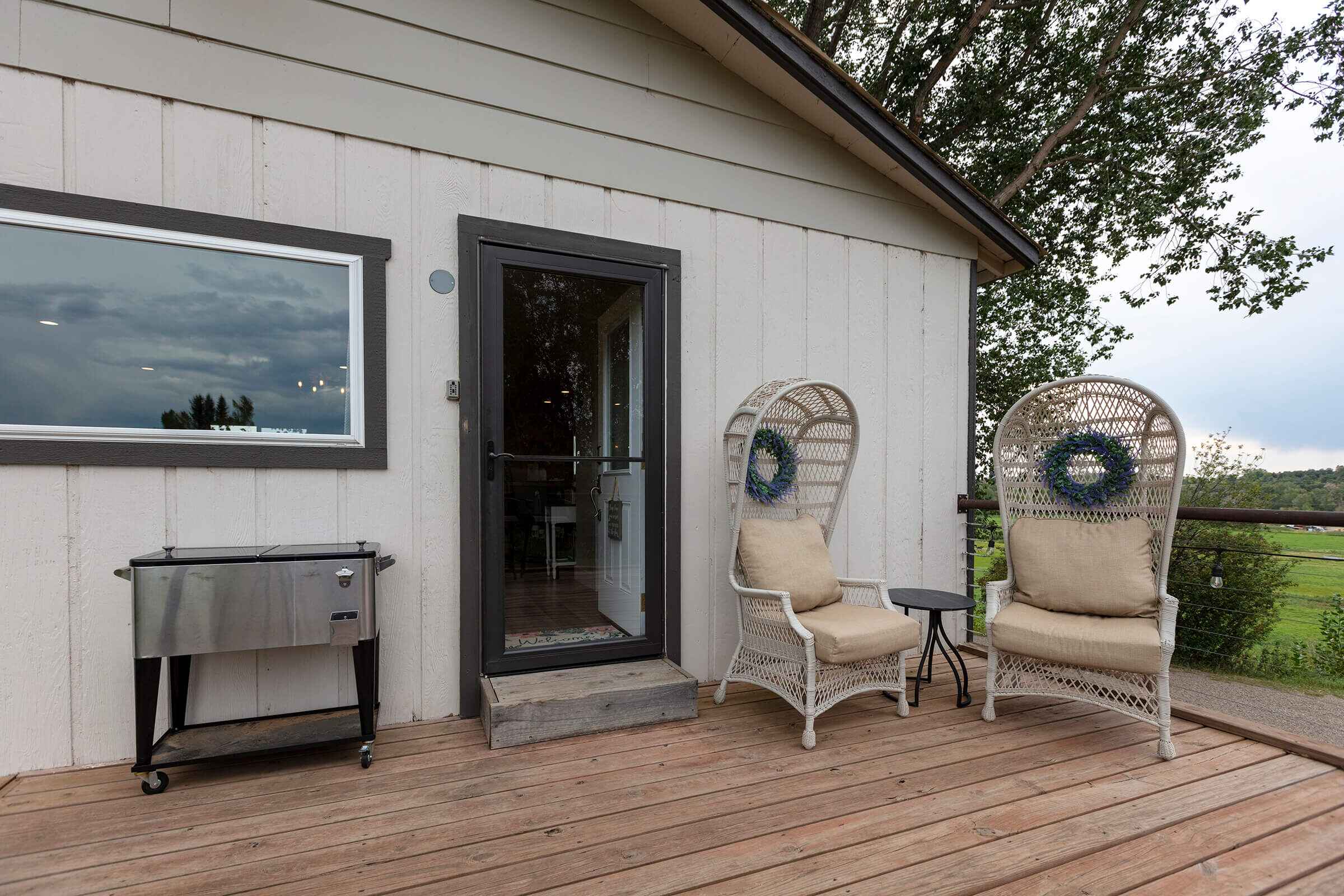 The Loft deck entrance with peacock chairs and stainless cooler