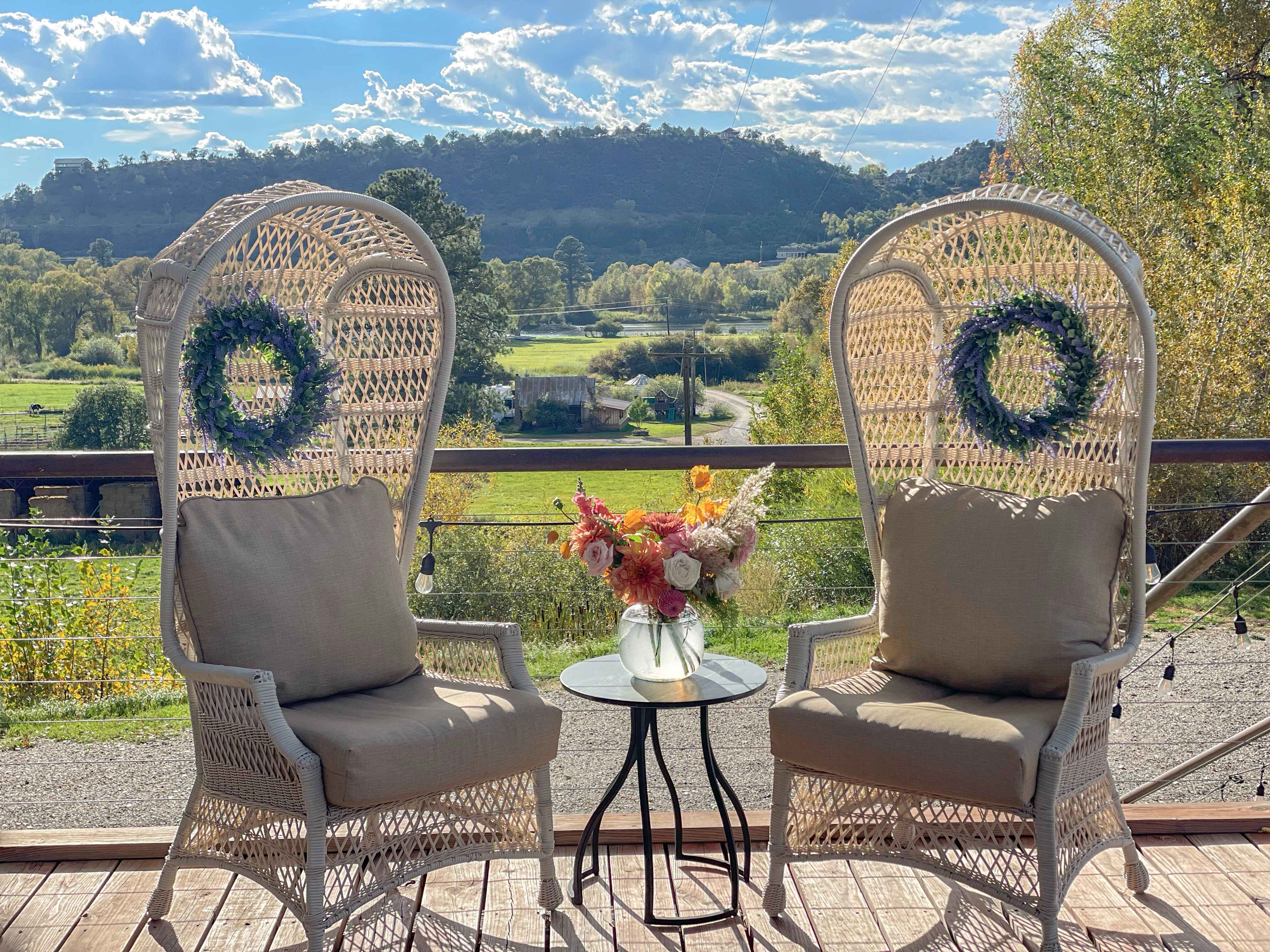 Peacock chairs with fresh flowers overlooking the valley from The Loft deck