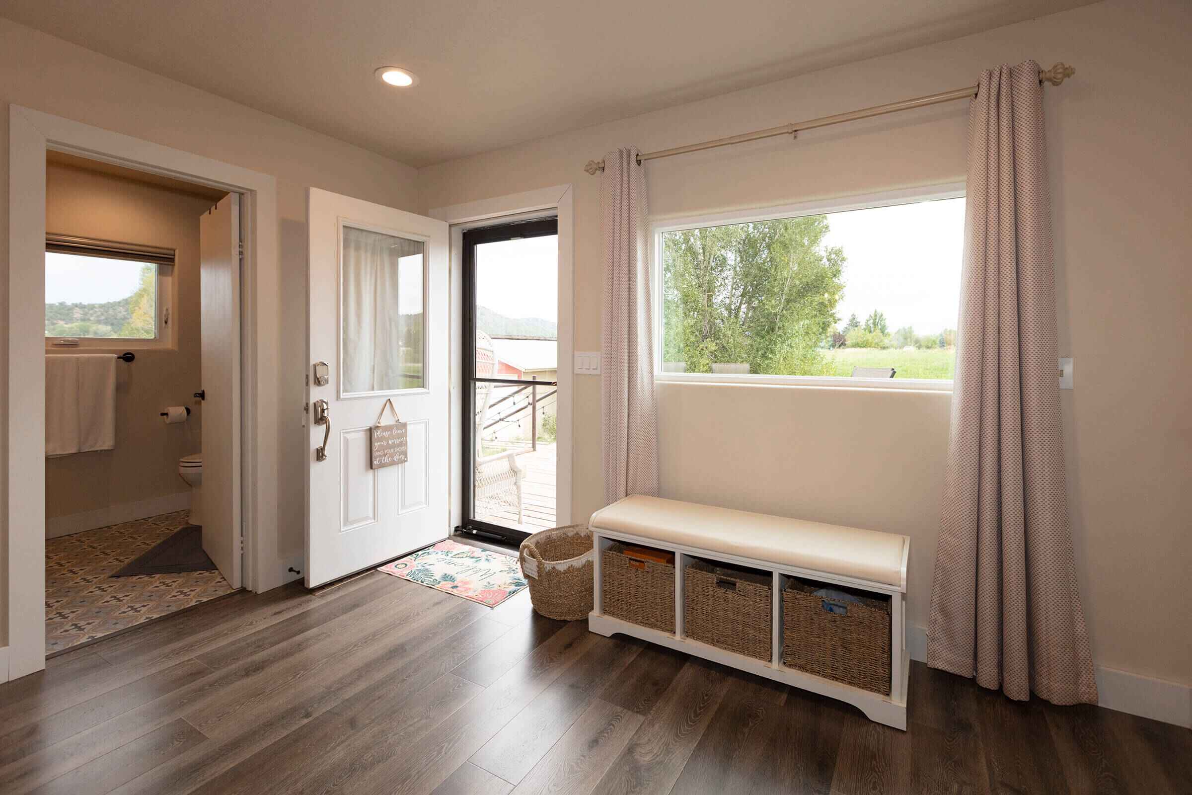 The Loft entryway with storage bench and picture window overlooking the ranch