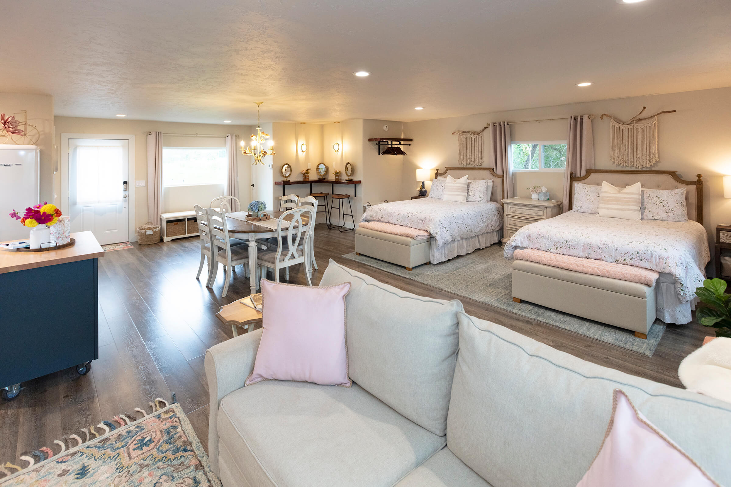 The Loft open-concept interior with couch, two queen beds, dining area, and kitchen