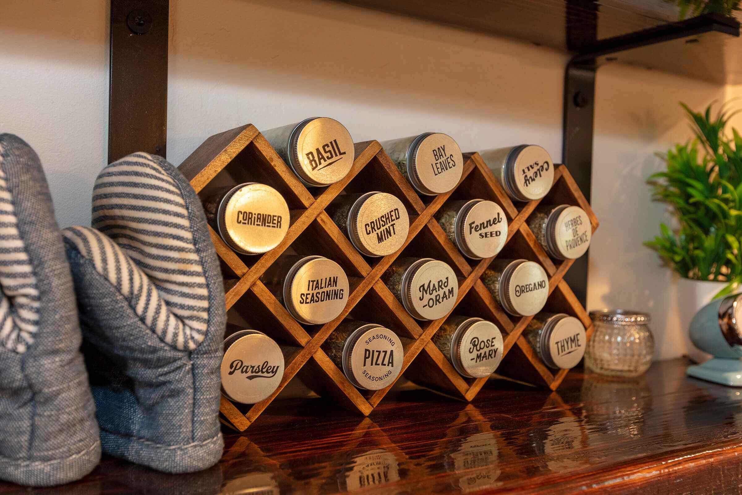 Hand-labeled spice rack with herbs on the polished wood kitchen counter